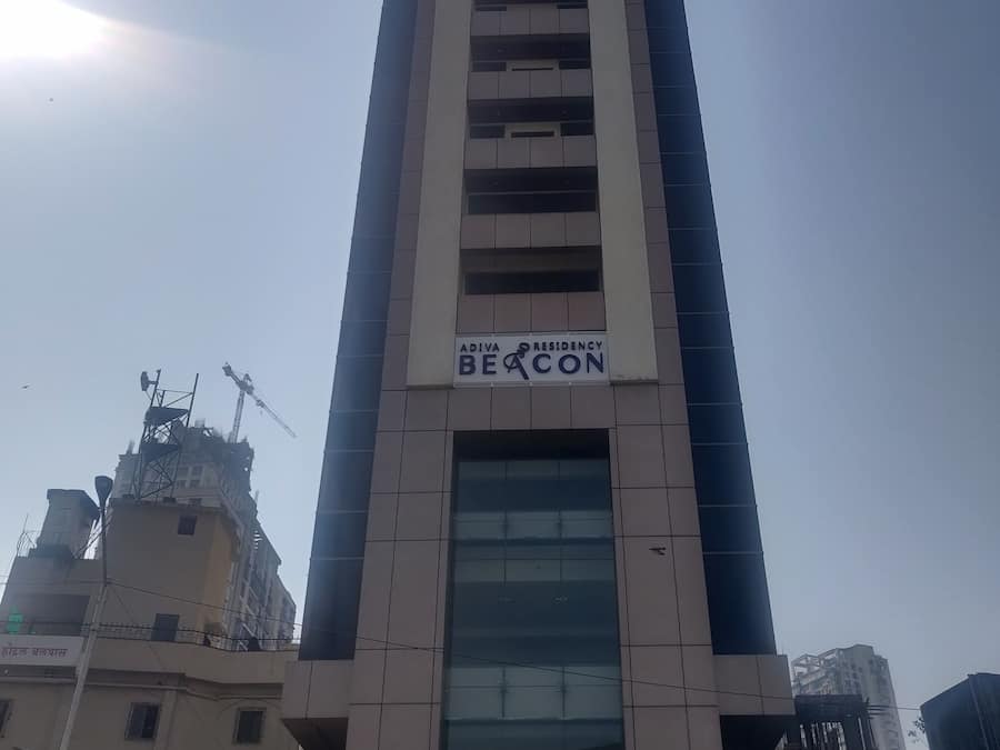 A tall building with a sign reading "Adiva Residency Beacon".
