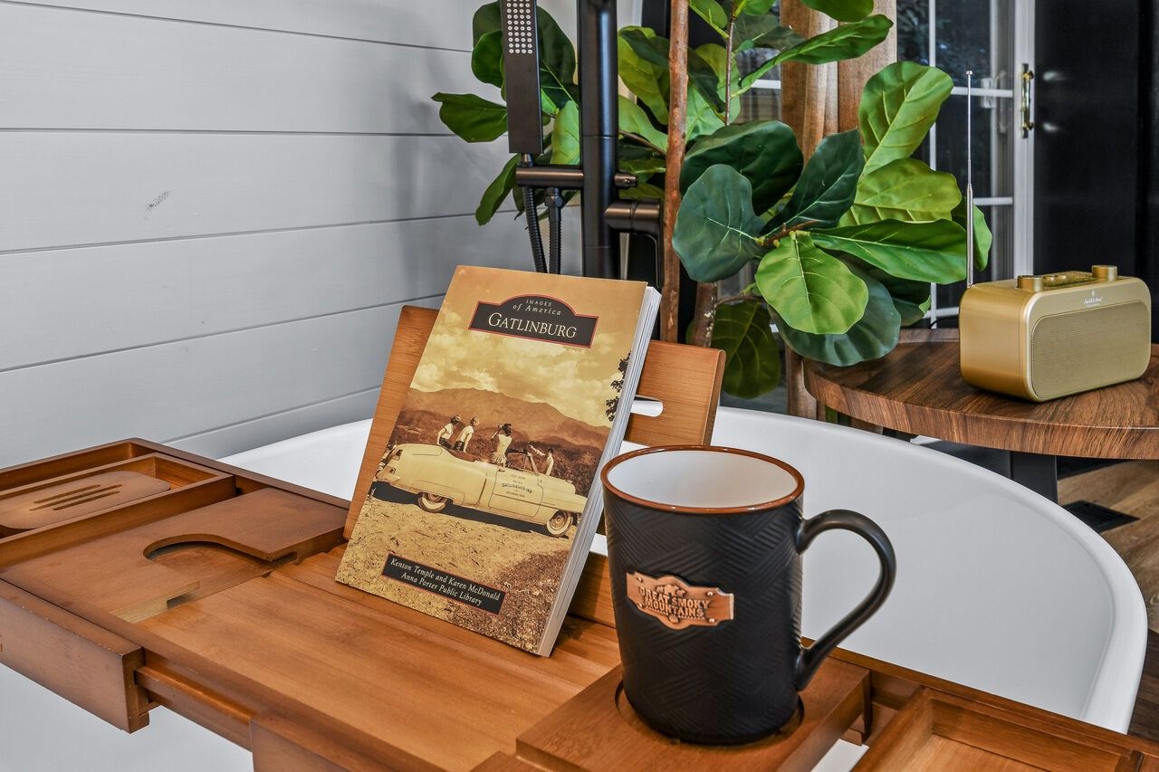 A wooden tray with a book titled 'Catlinburg' and a black mug with a label.