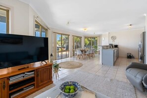 Relax in this spacious living area with a large flat-screen TV and dining table, perfect for family meals.