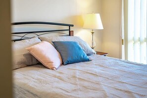 Cozy retreat with a comfortable bed and bedside lamp.