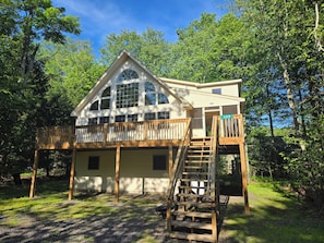 A two-story house with a balcony and a wooden staircase.