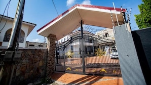 A gated entrance with a metal gate and a covered area.