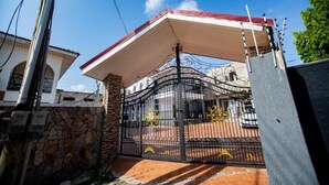 Una entrada cerrada con portón metálico y zona cubierta.