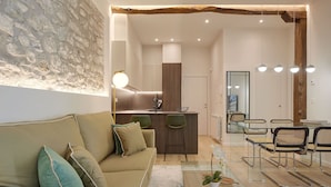 A modern living room with a sofa, a glass coffee table, and a dining area with chairs and a table. - Idiakez by FeelFree Rentals (San Sebastián)