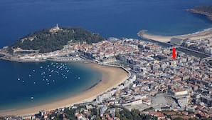 An aerial view of a coastal city with a prominent hill, a beach, and a dense urban area. - Idiakez by FeelFree Rentals (San Sebastián)