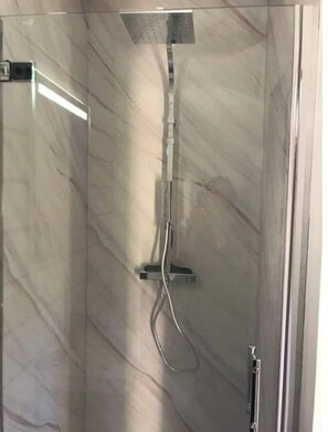 Een douche, een haardroger, handdoeken, toiletpapier