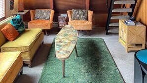 Une pièce chaleureuse avec un plafond en bois, un escalier et une moquette verte.