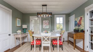A dining area with a round table, chairs, a chandelier, and artwork on the walls. - Charming Gingerbread House. Awesome mountain views near to SNP and Skyline Dr. (Penn Laird)