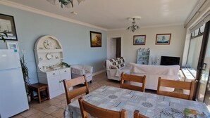 Uma cozinha compacta com mesa, cadeiras e geladeira.