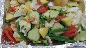 A meal tray with grilled squid, diced potatoes, and a mixed vegetable salad. - Amani Paje B&B (Paje)