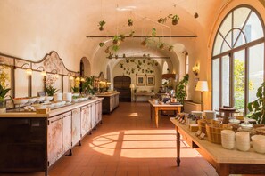 A spacious hotel lobby with a long reception counter, arched ceilings, and hanging plants. - QC Grand Hotel Villa Arzaga Garda Spa & Golf (Calvagese della Riviera)