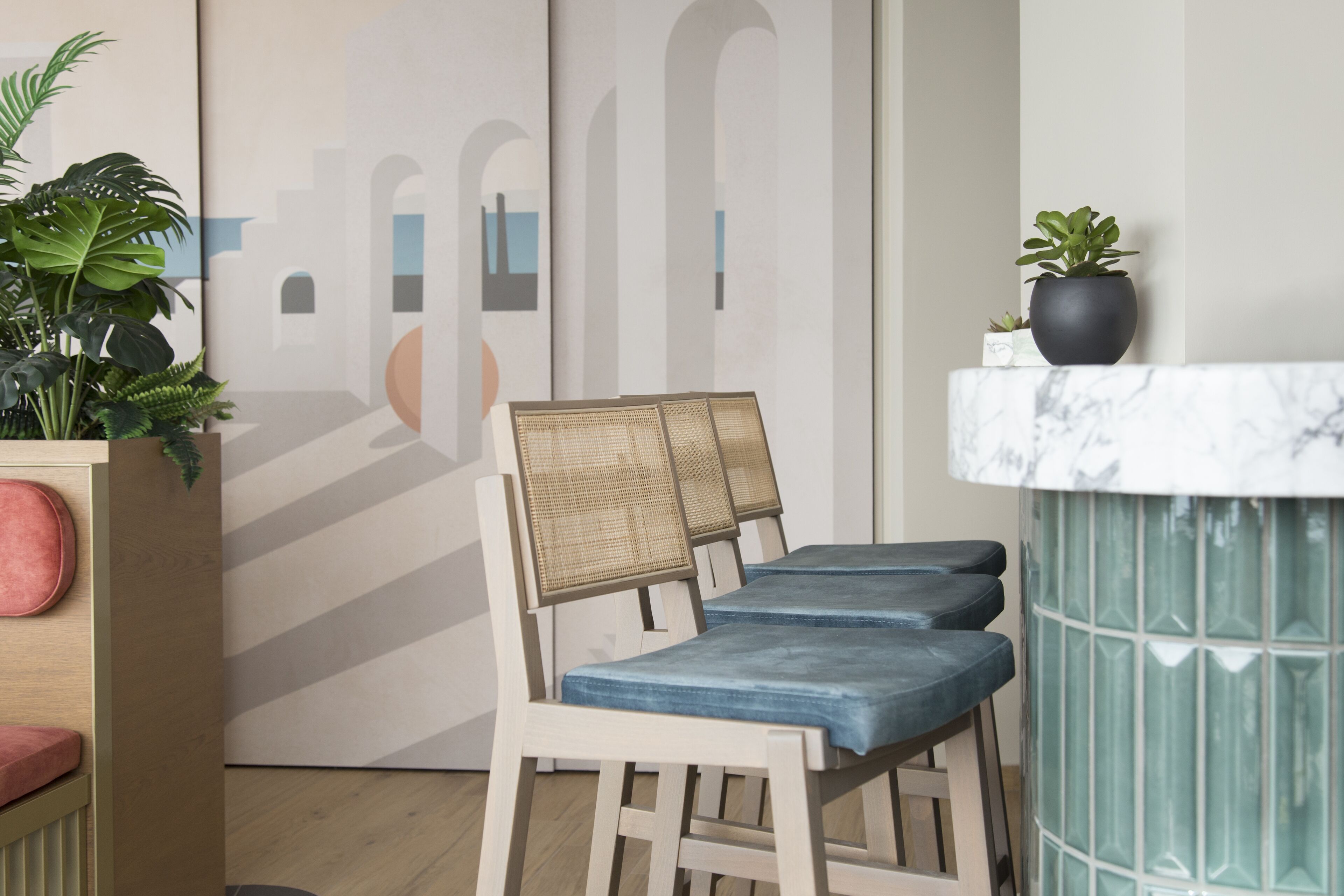 A seating area with three chairs, a small table, and a potted plant.