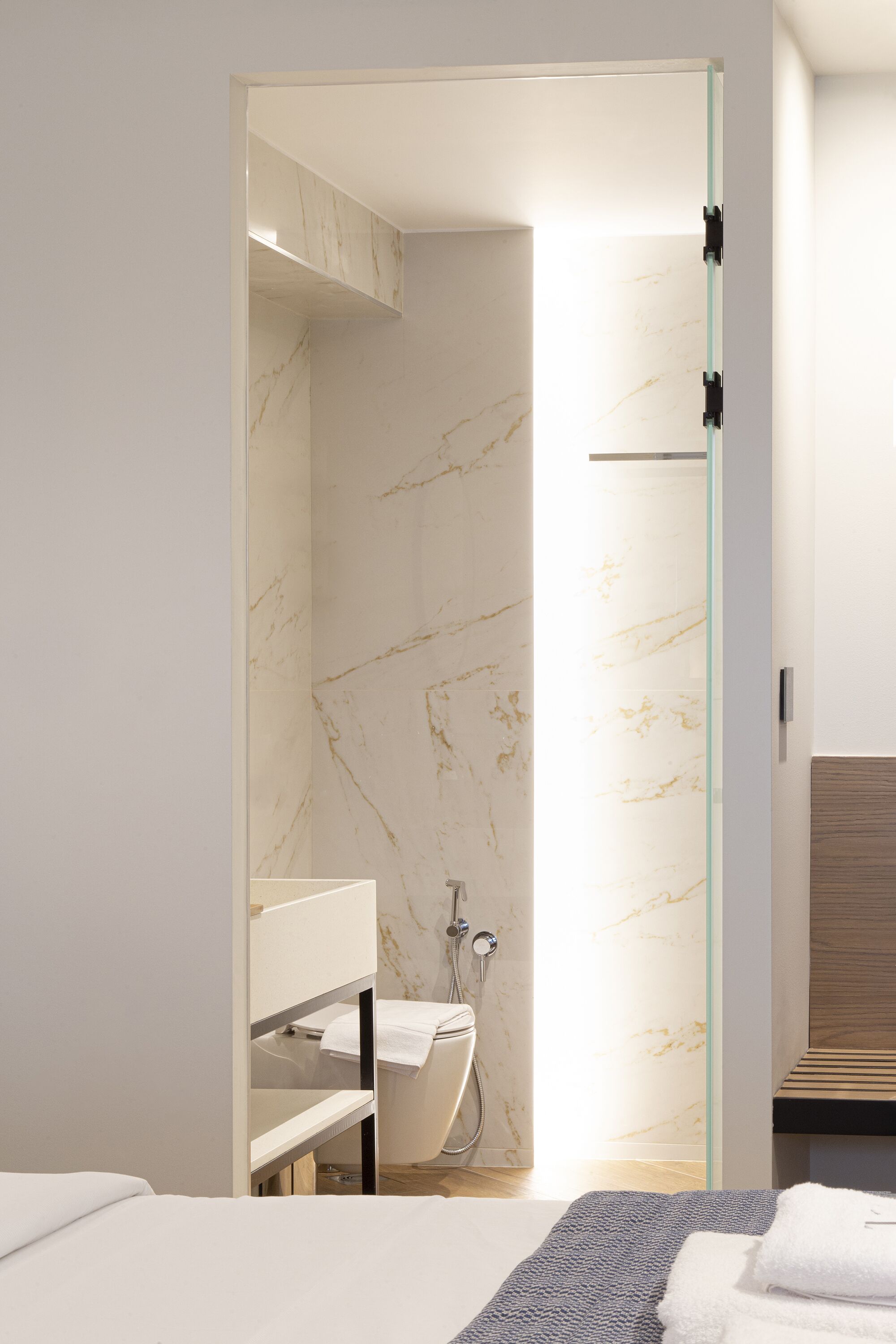 A modern bathroom with a glass shower enclosure, a white toilet, and a wooden vanity.