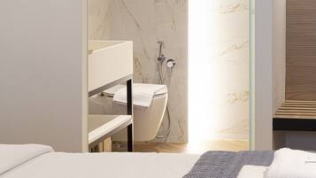 A modern bathroom with a glass shower enclosure, a white toilet, and a wooden vanity.