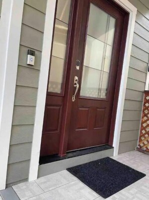 Welcome to a charming entryway with a dark front door, glass panel, and a convenient mailbox.