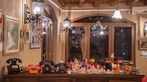 A vintage-themed room with wooden cabinets, antique telephones, and decorative items on a counter. - Hotel Tutto (Hotel Tutto)