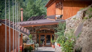 A wooden building with a stone facade and a balcony. - Hotel Tutto (Hotel Tutto)