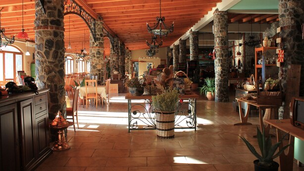A spacious lobby with stone pillars, wooden beams, and hanging chandeliers. - Hotel Tutto (Hotel Tutto)