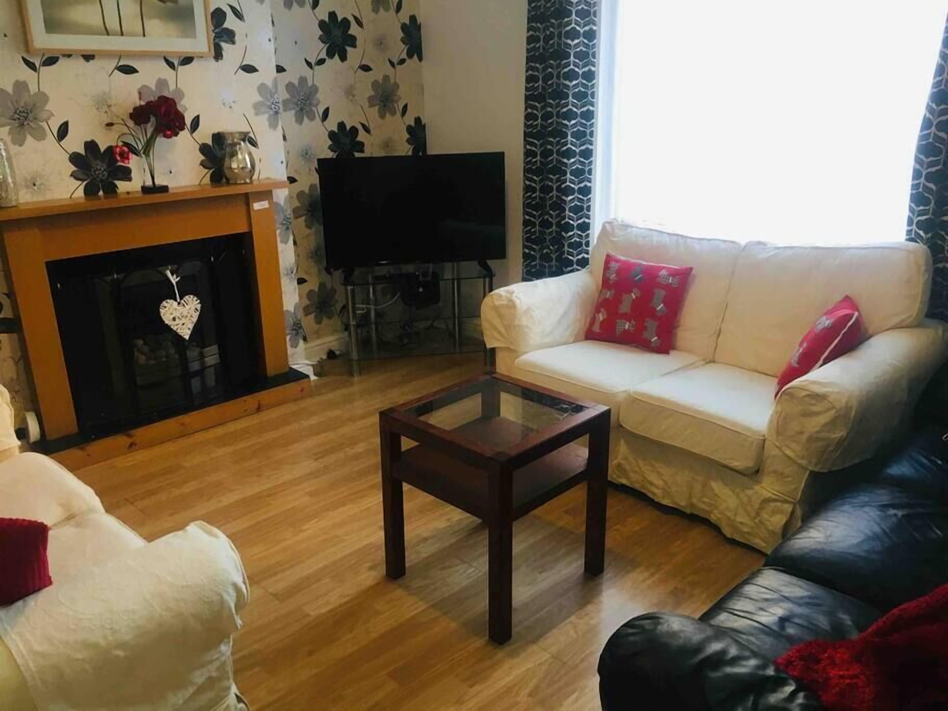 Un salon avec un canapé, une table basse, une cheminée et un téléviseur.