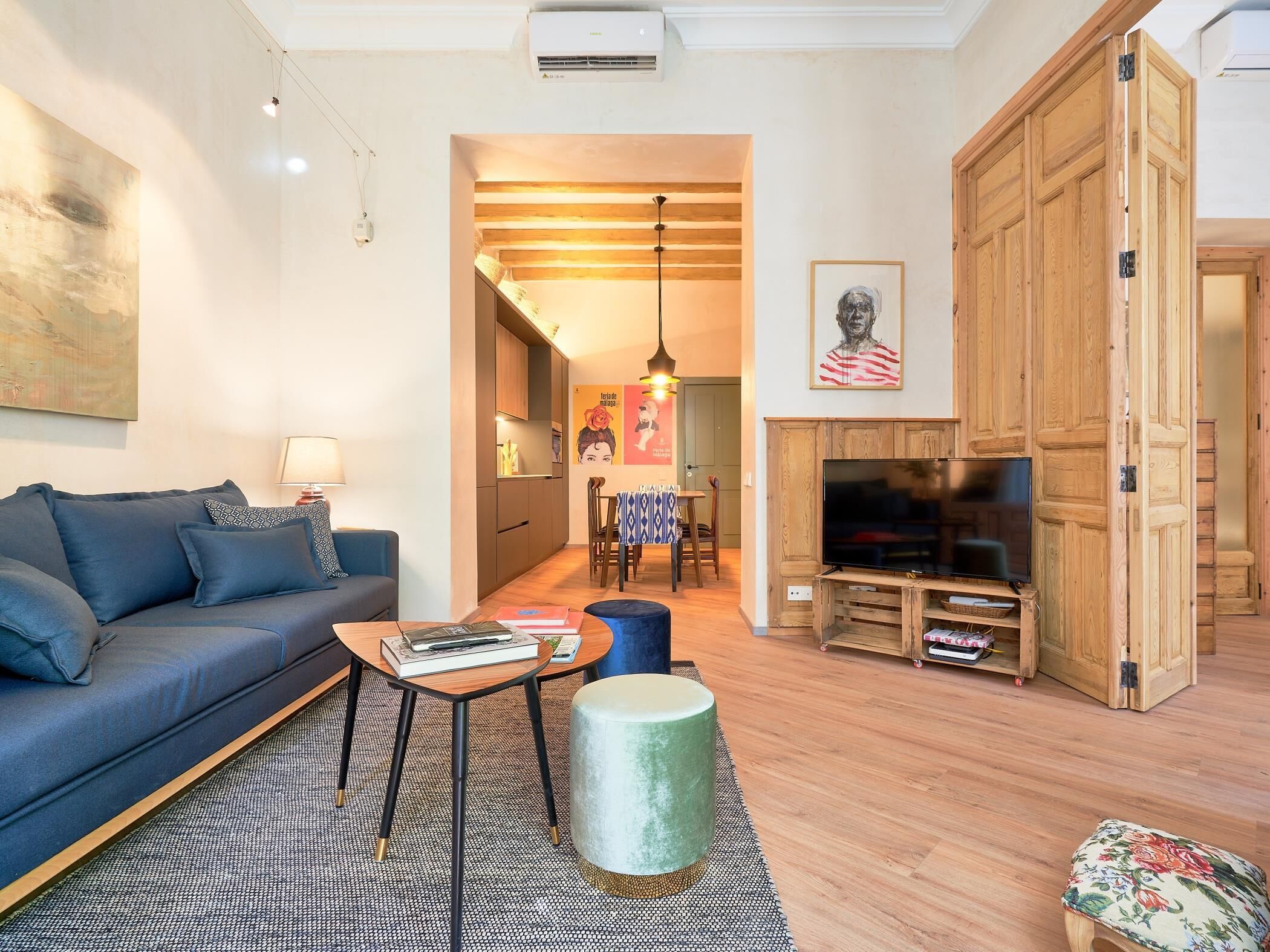 A modern living room with a sofa, coffee table, and a TV stand.