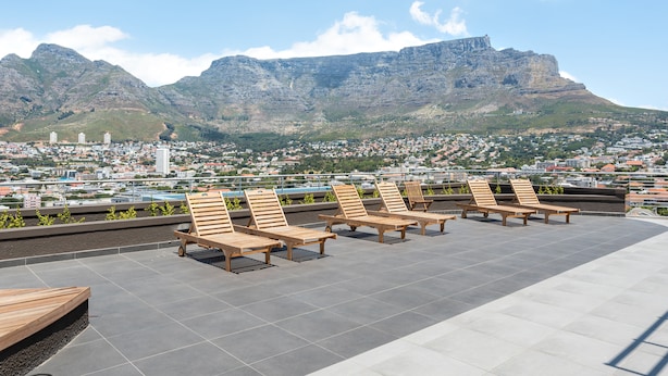 A rooftop terrace with wooden loungers and a cityscape view. - FortyonL 709 (Cape Town)