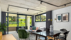 A modern dining area with a glass partition, a sofa, and a dining table with chairs. - FortyonL 709 (Cape Town)