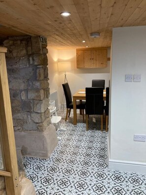 Cozy retreat with a dining area, stone accent wall, and warm ambiance.