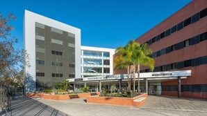 A university building with a modern design, featuring a large glass facade and a brick exterior. - Micampus Rector Estanislao del Campo - Students Residence (Seville)