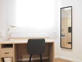 Un ufficio dal design minimalista con scrivania, sedia e un grande specchio.