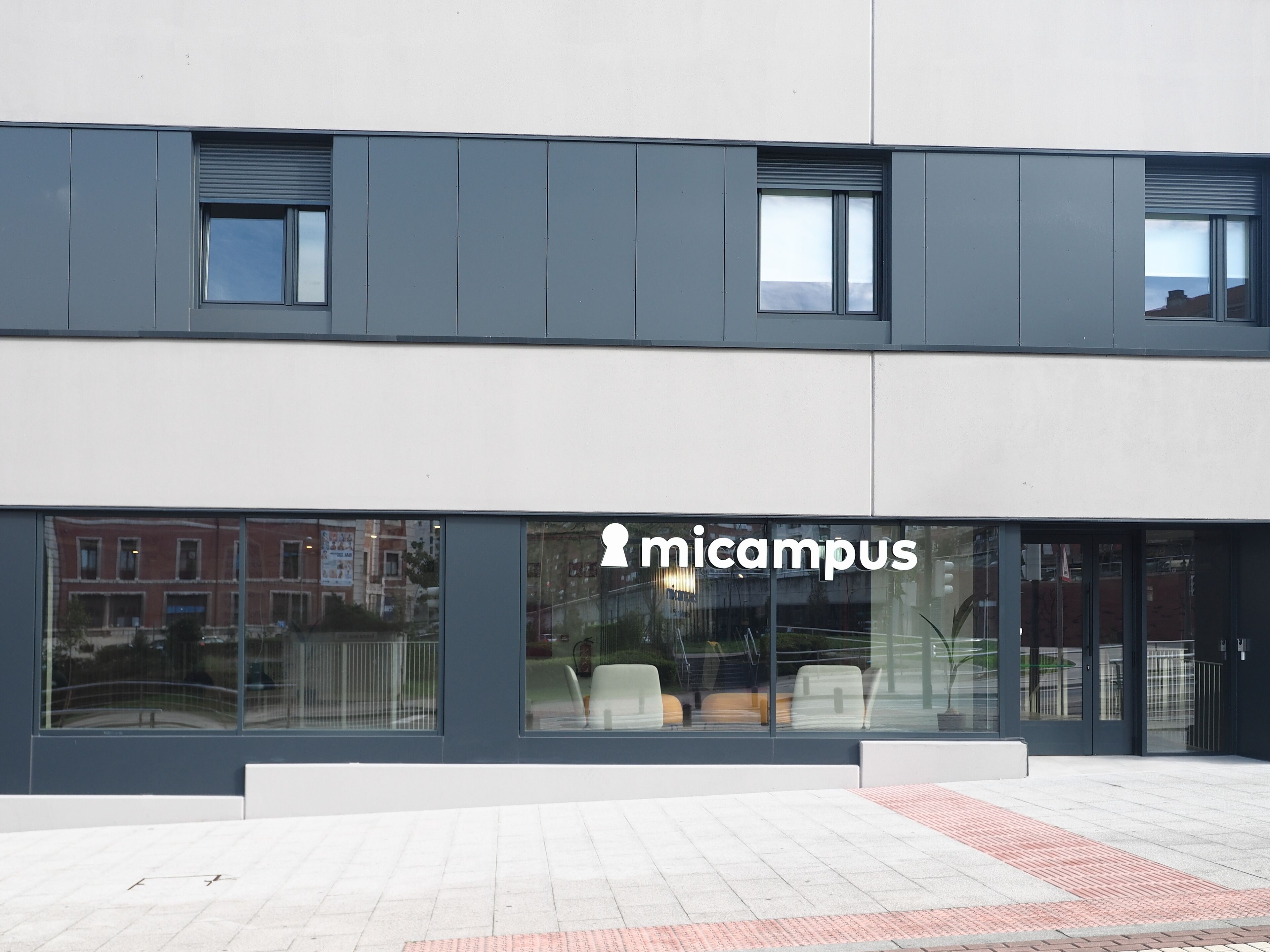 A modern building with large windows and a sign reading "micampus".