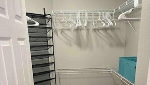 A small closet with shelves, a shoe rack, and storage bins.