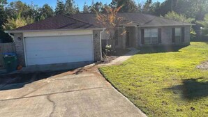 A residential property with a garage, a lawn, and a driveway.