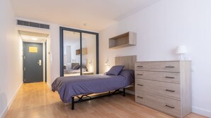 Un dormitorio moderno con una cama, un aparador y un vestidor.