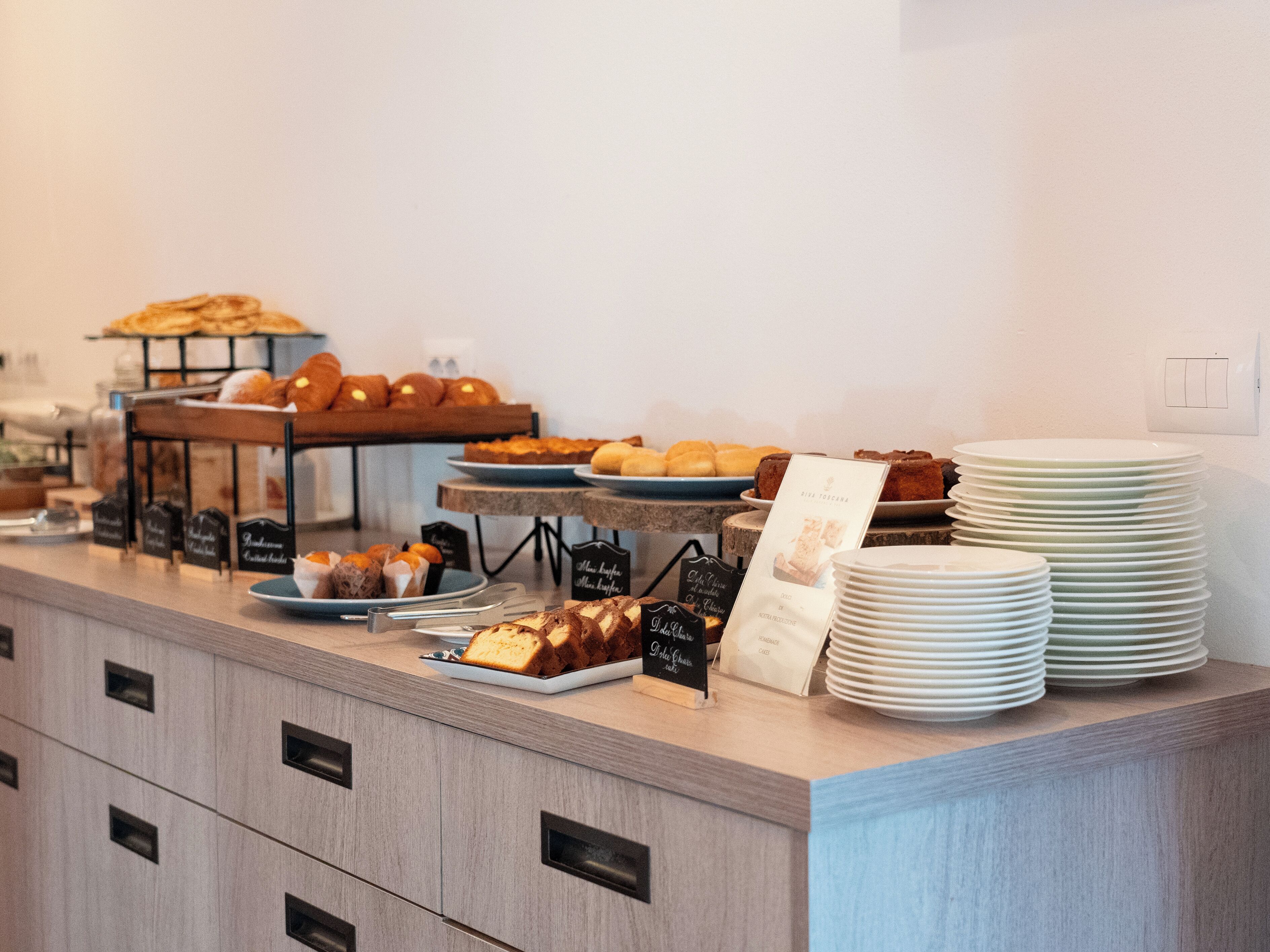 A buffet counter with various baked goods and pastries.