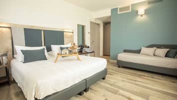 Ett modernt hotellrum med en stor säng, en soffa och ett litet bord med ett bricka på.