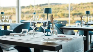 A dining table set with wine glasses, a vase with dried flowers, and a lamp. - Riva Toscana Golf Resort & SPA (Follonica)