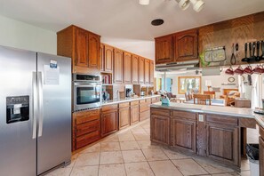 A modern kitchen with wooden cabinets, stainless steel appliances, and a central island. - The Roost: Mesa-Edge Valley Views, Hot Tub & Fenced Dog Orchard near Grand Mesa (Cedaredge)