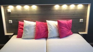 Un lit avec une tête de lit en bois et plusieurs luminaires.