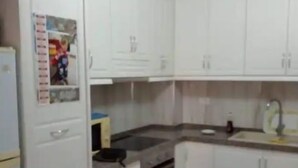 Uma cozinha com armários brancos, um fogão e uma pia.