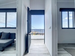 A modern interior with a sofa, a view through a glass door, and a tiled floor. - Casa da Av by Atlantic Holiday (Machico)