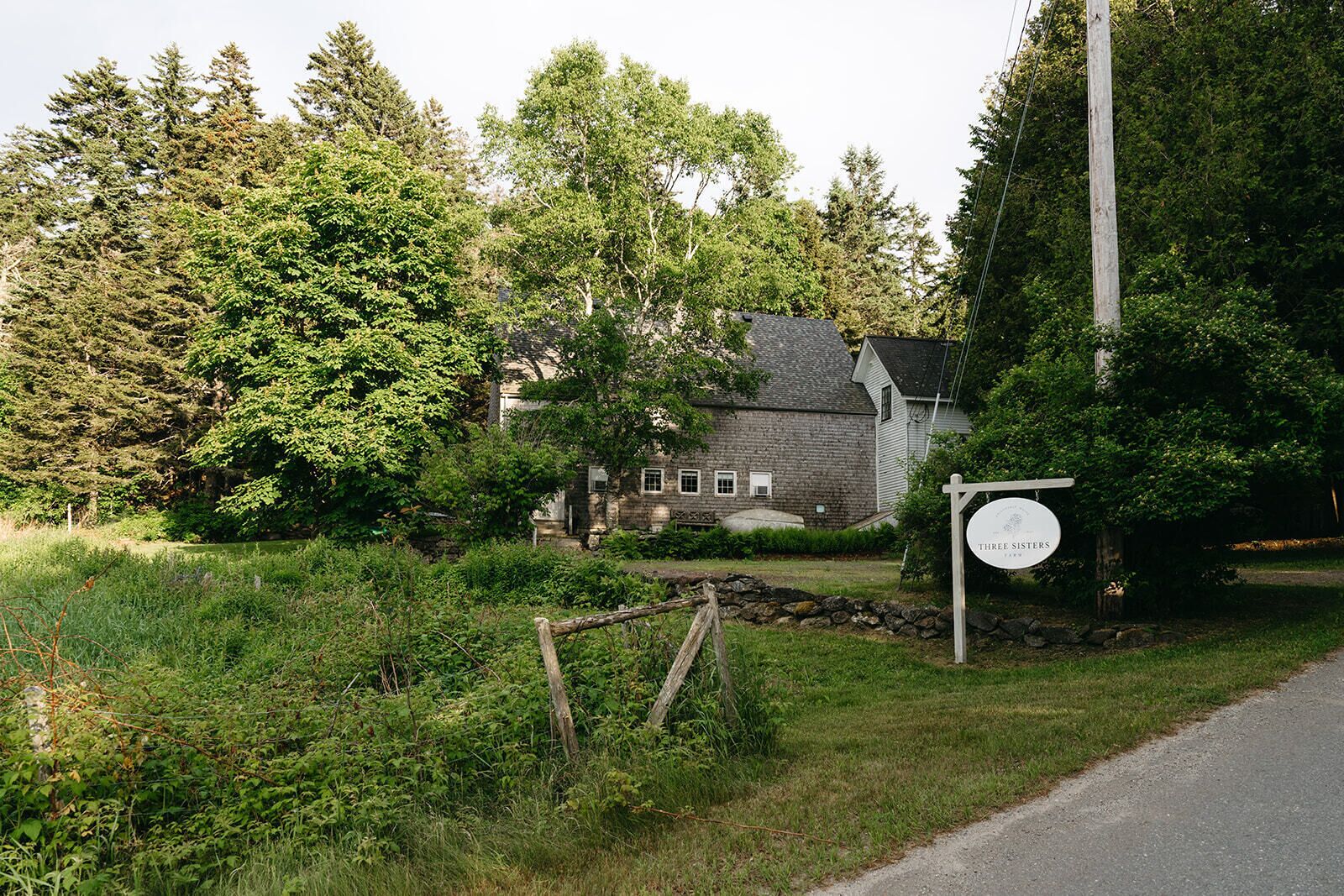 A rustic stone building with a sign reading "Three Sisters."