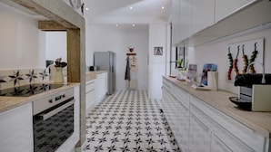 Una cocina moderna con piso de baldosas geométricas, armarios blancos y una isla central.