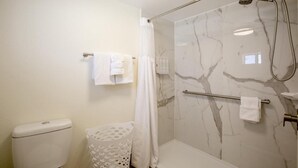 Ein Badezimmer mit Toilette, einer Duschkabine und einem Handtuchhalter.