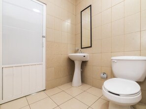 Ein Badezimmer mit Toilette, Waschbecken und Spiegel.