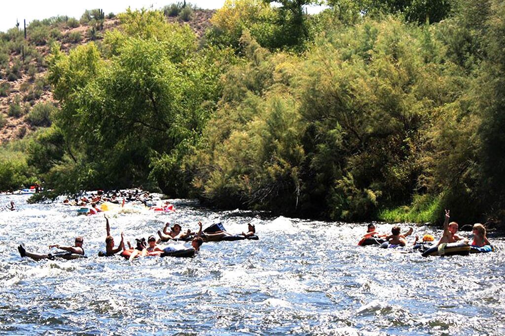 Un río con gente flotando en balsas.