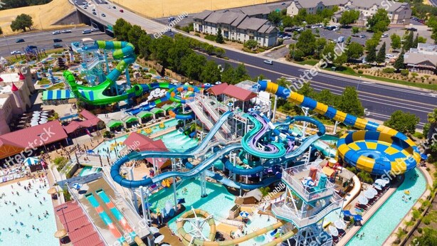 An aerial view of a water park with multiple slides and pools, surrounded by buildings and roads. - Gilbert Luxury Remodel ~ EV Charger, 1-Level Comfort, Family & Pet-Friendly (Gilbert)