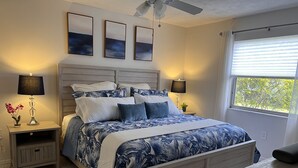 A bedroom with a bed, nightstands, lamps, and a window with blinds. - Centrally located Condo, Sarasota Fl 34232 (Sarasota)