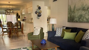 A modern living room with a blue sofa, green armchair, and a wooden coffee table. - Centrally located Condo, Sarasota Fl 34232 (Sarasota)