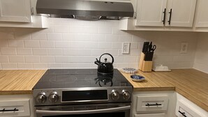 A kitchen with a stainless steel stove, oven, and white cabinets. - Centrally located Condo, Sarasota Fl 34232 (Sarasota)