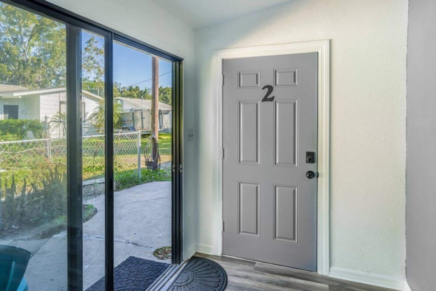 A door with the number 2, a sliding glass door, and a doormat.